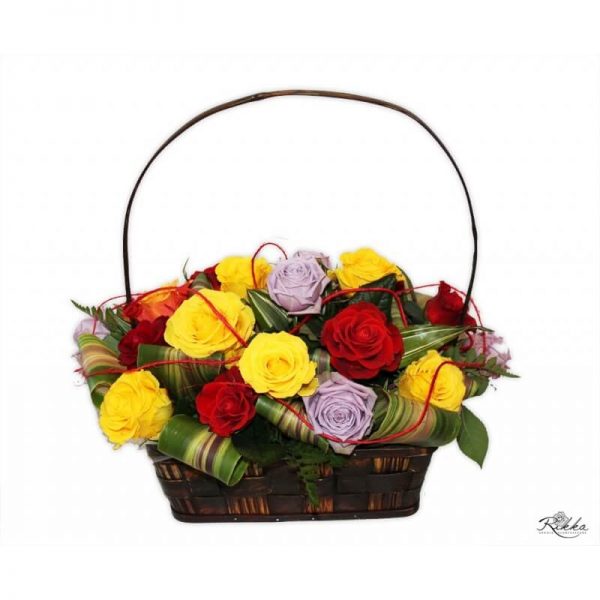 Koszyk z kolorowych róż z dodatkiem wywiniętych liści kordyliny.
